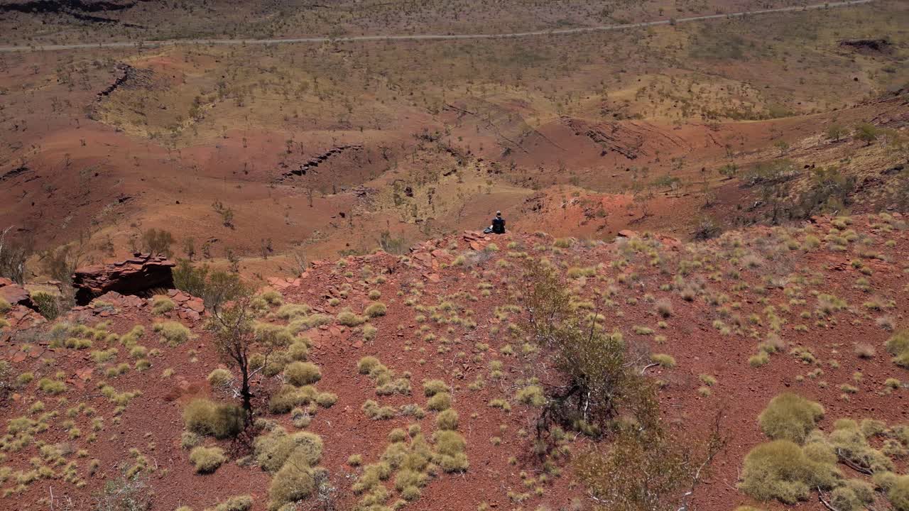 서 오스트레일리아 사막 의 높은 절벽 의 가장자리 에 앉아 있는 사람 의  ⁇ 도 촬영