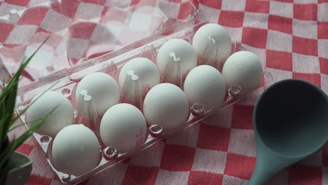 eggs in carton on checkered tablecloth