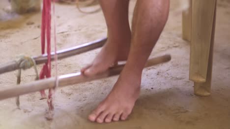 máquina mecánica de algodón de seda controlada por los pies en una aldea india rural