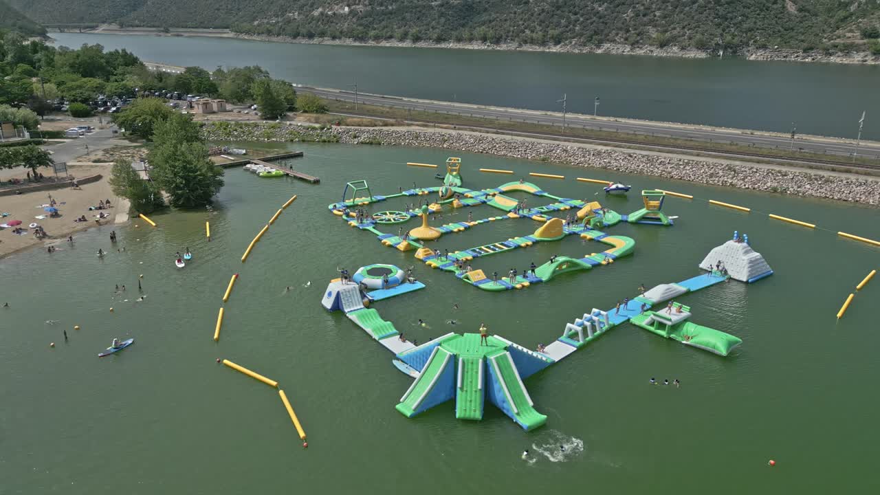 Aerial Fly Inflatable Water park in French Lake Landscape, highway road at Vinca commune, Pyrenees-Orientales