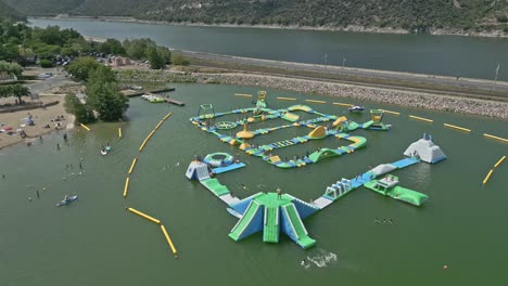 aerial fly inflatable water park in french lake landscape, highway road at vinca commune, pyrenees-orientales