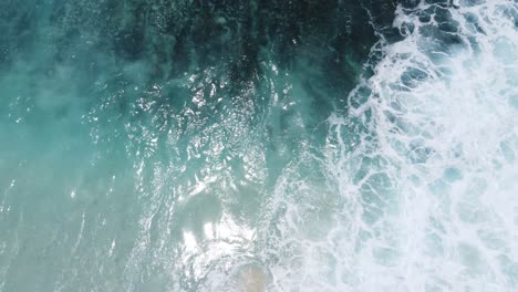 perspectiva de arriba hacia abajo de las olas que se estrellan en la playa de diamantes en la isla de nusa penida bali, indonesia