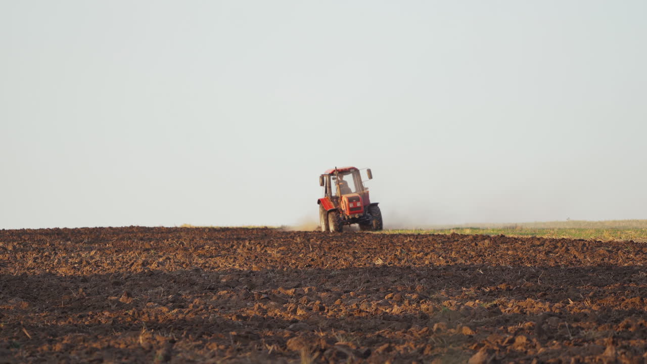 Farmer working in the field. Farmer in tractor preparing land with seedbed cultivator