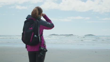 rear view of adult adventurous woman looking out over the ocean