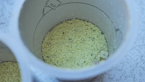 unprepared instant mashed potato flakes with seasoning in plastic cup, ready to eat