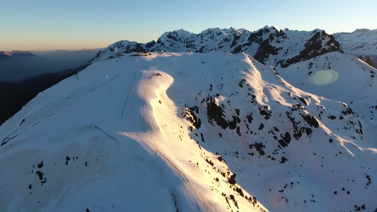 pista de esquí cuesta abajo en chamrousse en los alpes franceses durante el amanecer, tiro aéreo con plataforma rodante
