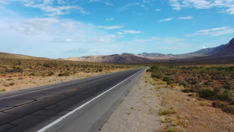 cinematic shot of an empty road highway with mountains at red rock canyon in nevada’s mojave desert, usa