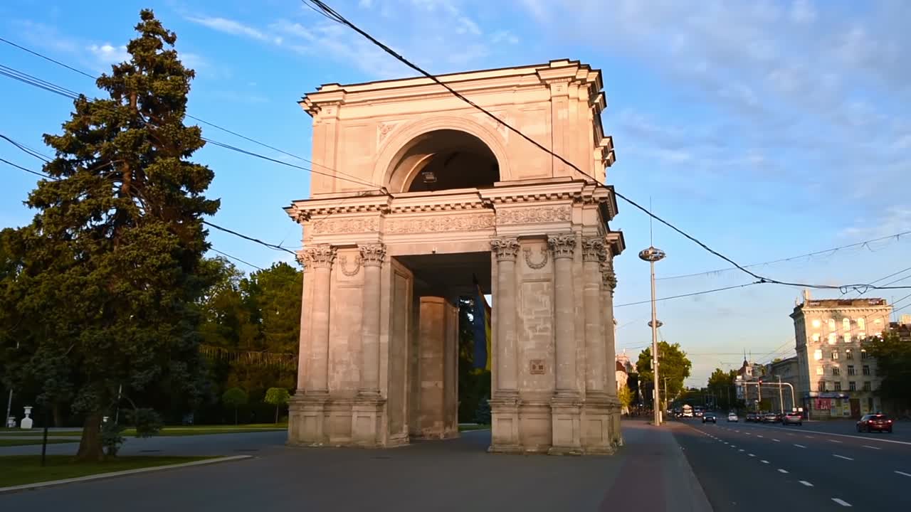 Triumphal Arch with driving cars in center of the city at sunset. Slow motion