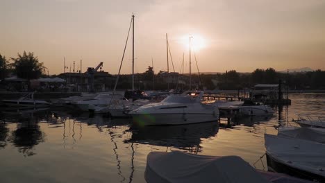 Ruhige-Landschaft-Des-Kleinen-Hafens-Am-Gardasee-Bei-Sonnenuntergang,-Glänzende-Wasseroberfläche,-Die-Sich-Kräuselt
