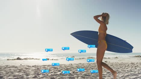 animation of social media reactions over happy caucasian woman with surfboard walking on beach
