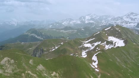 Aéreo:-Tiro-Alto-Sobre-Los-Alpes-Europeos,-Paisaje-De-Primavera-De-Montaña-Nevada