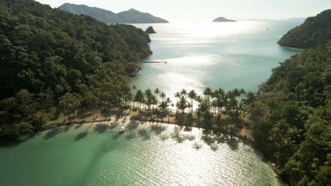 antena de isla tropical unida por una playa de arena con palmeras y sombras de palmeras en el océano en tailandia