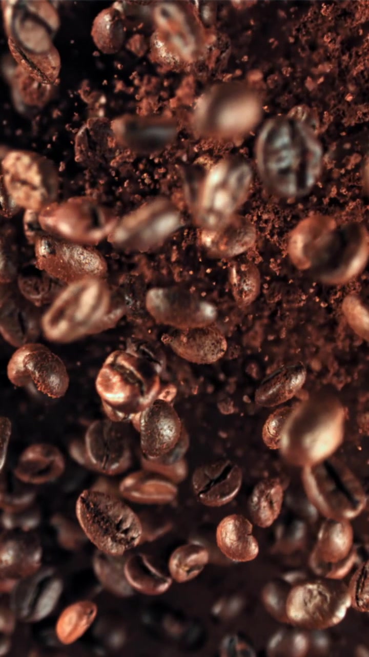 Chicchi di caffè tostati e caffè macinato che cadono al rallentatore