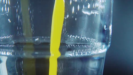 a macro close up shot of a glass filled with fresh squeezed orange juice, slow motion, studio light, 4k video