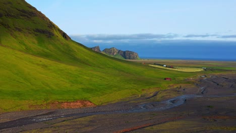 picturesque of greenery mountains with flowing river near geothermal pool of seljavallalaug, southern iceland