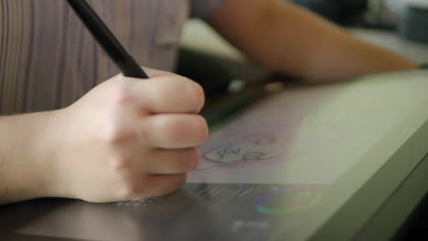 a caucasian woman's hand draws a digital illustration on a tablet in slow motion