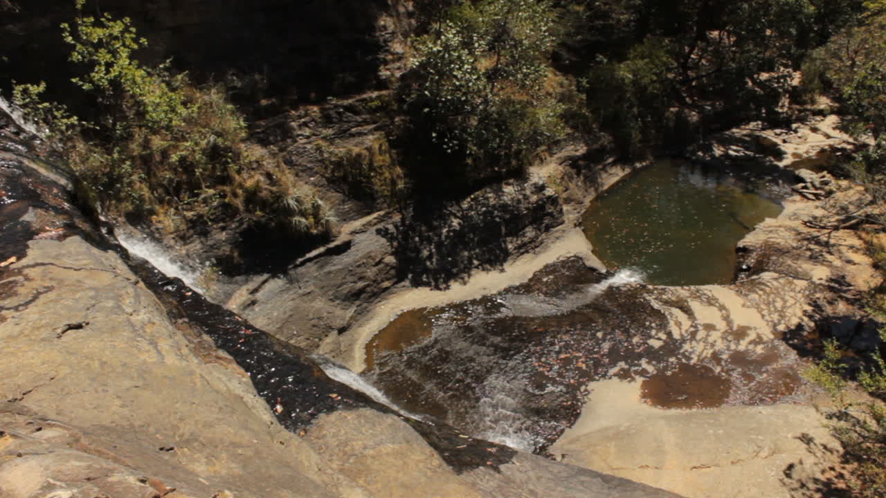 curso de cascada al lago rodeado de bosque