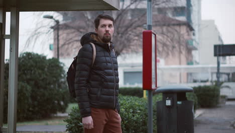 man waiting at a bus stop