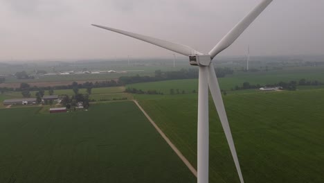 Windmill-Turning-At-DTE-Wind-Farm-With-A-View-Of-Vast-Green-Meadow-In-Ithaca,-Gratiot-County,-Michigan