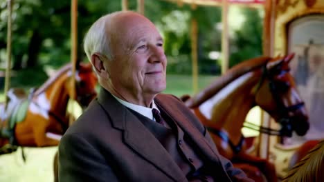 senior man at a vintage carousel