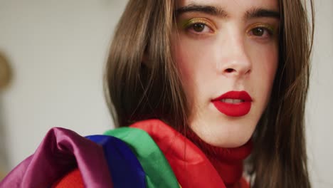 Portrait-of-caucasian-non-binary-transgender-woman-holding-lgbt-flag