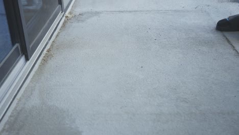 person cleaning patio with brush broom. close up