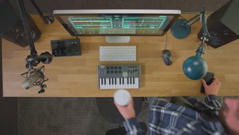 Vista-Aérea-Del-Músico-Masculino-En-La-Estación-De-Trabajo-Con-Teclado-Y-Micrófono-En-El-Estudio.