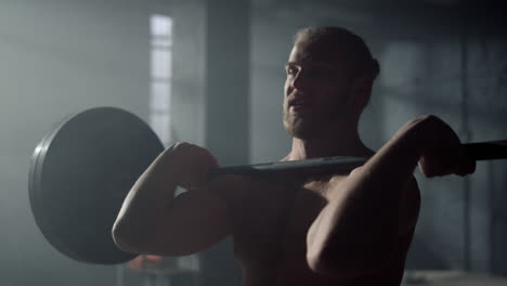 man doing squat with barbell during training. male bodybuilder exercising in gym