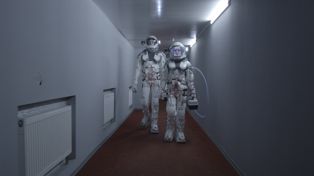 Two Astronauts Walking in a Futuristic Corridor