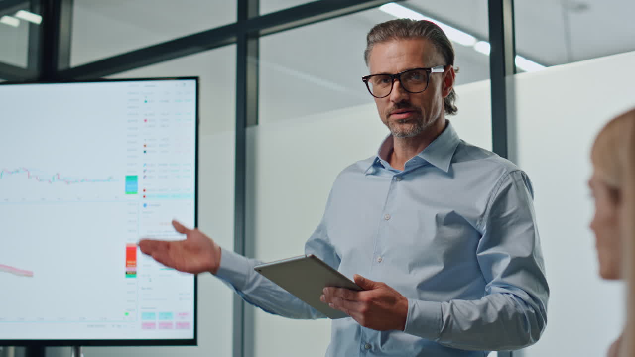 hombre confiado apuntando a la pantalla en la sala de reuniones. especialista presentando la puesta en marcha