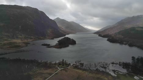 Overcast-view-of-Glenfinnan-Viaduct-in-Scotland,-with-surrounding-loch-and-hills,-dramatic-clouds-overhead