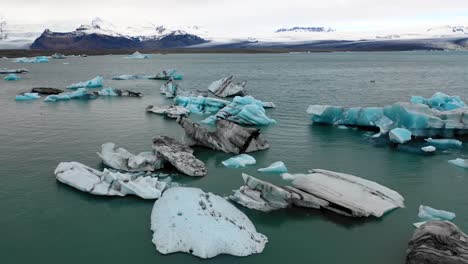 low flyover of icebergs in jokulsarlon towards vatnajokull icecap