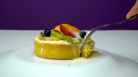 eating cake with blueberry, kiwi, orange, strawberries on the plate rotation.