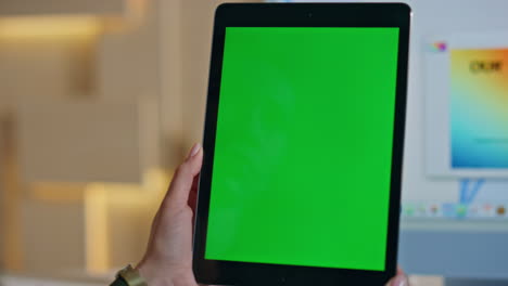 employee browsing greenscreen tablet application at studio workplace close up.
