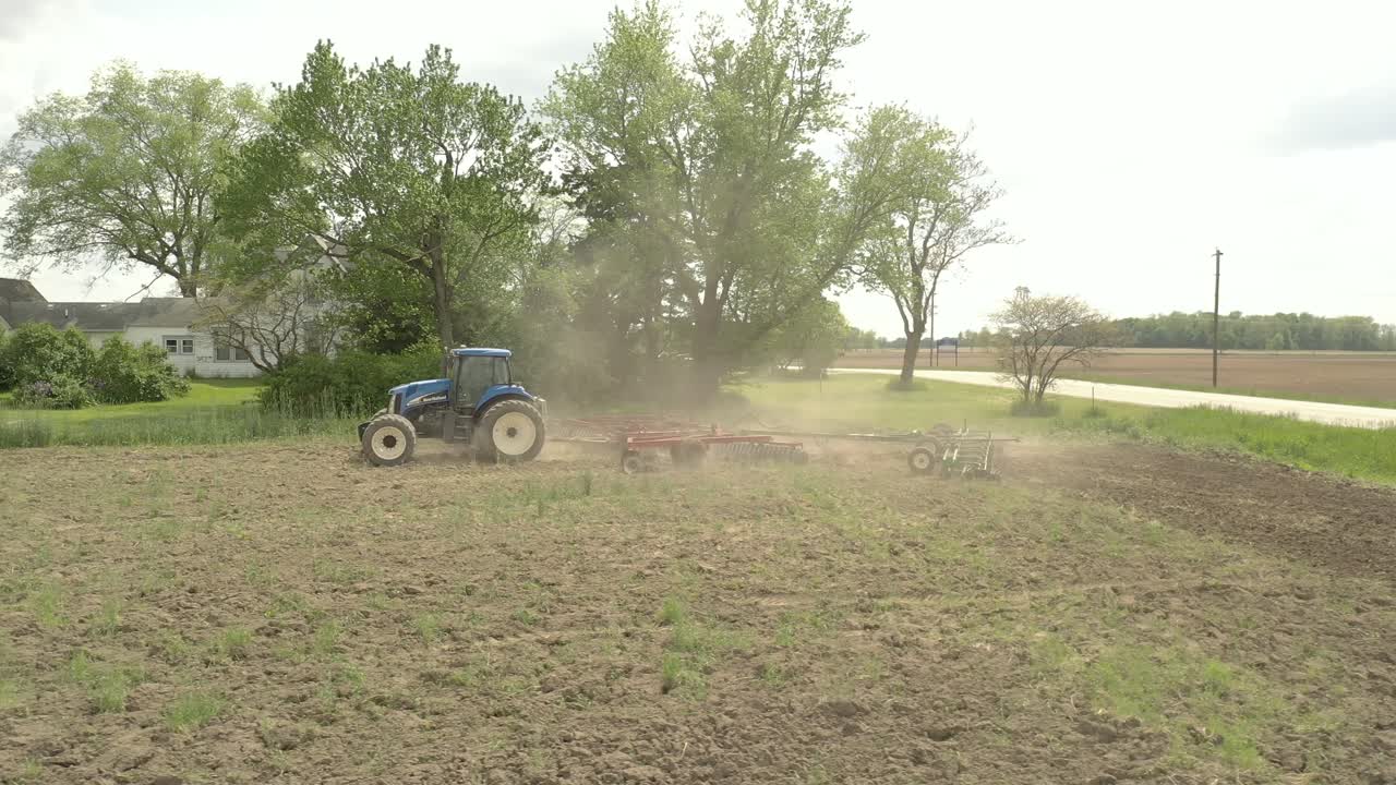 agricultor en tractor cultivando cosecha en campo toma 1