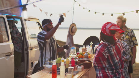 food truck seller cooking hot dogs for customers at summer festival