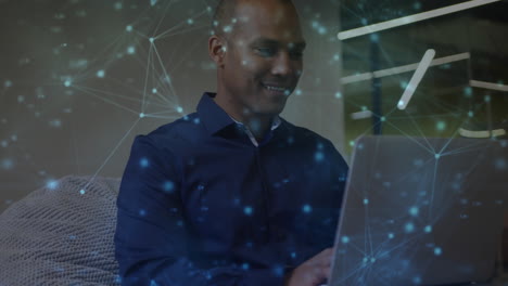 animación de la red de comunicación sobre un hombre biracial sonriente usando una computadora portátil en la oficina