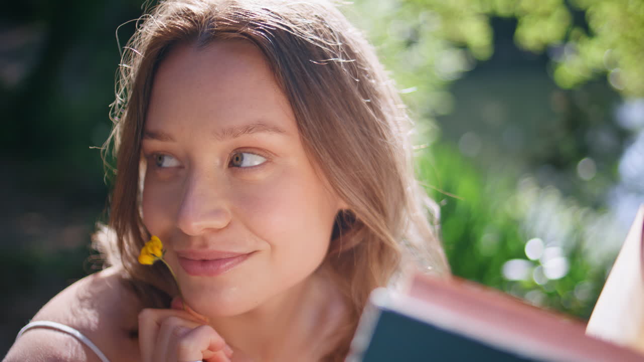 Sunny girl reading novel posing at greenery portrait. Woman flirting