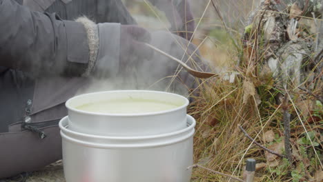 person making lunch outdoors with camping stove