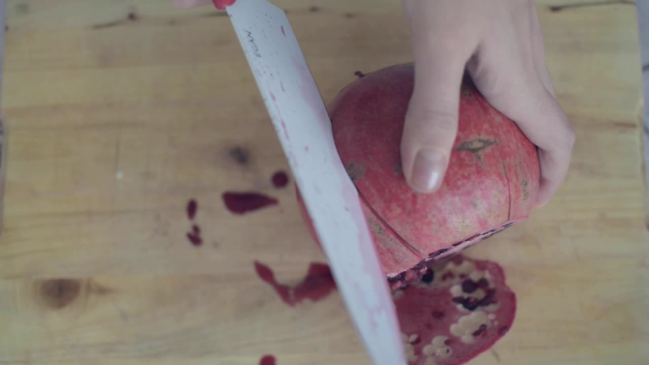 Making lateral cuts with the knife on pomegranate to easily open it