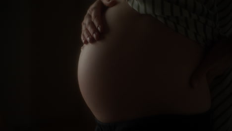 close up of pregnant woman massaging belly