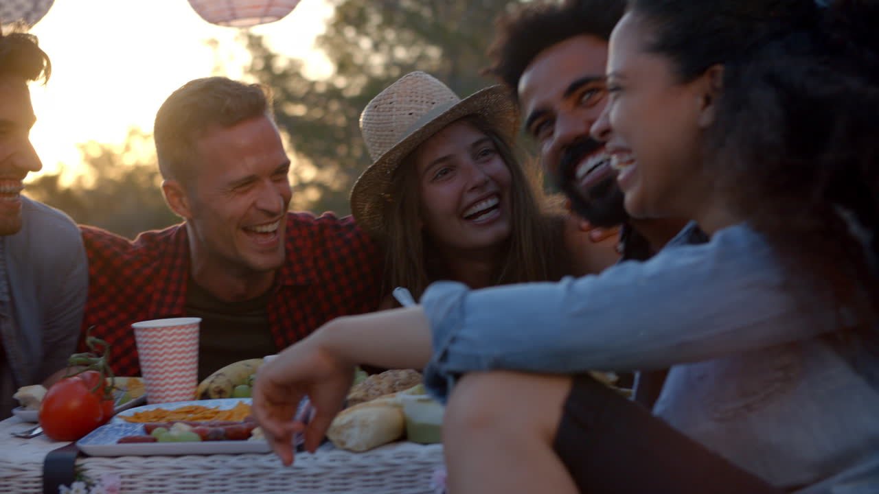 Amici che fanno un picnic accanto a un camper e chiacchierano