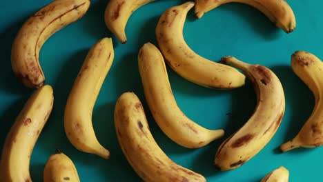 a macro shot of ripe yellow organic bananas rotating against a blue background