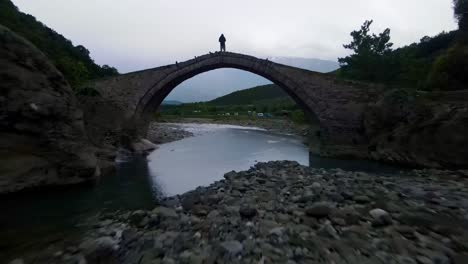 돌 다리 위 에 서 있는 남자 의 실루