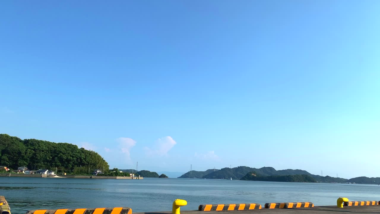 Amakusa  timelapse looking across Japanese harbour coastline to lush islands on horizon
