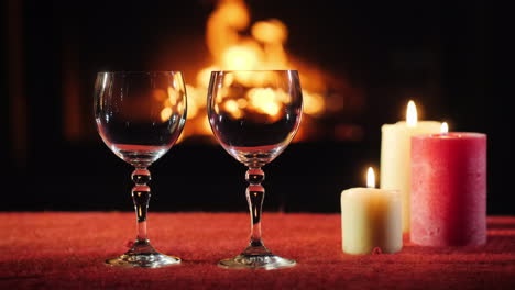 Two-Empty-Wine-Glasses-Candles-And-A-Fireplace-In-The-Background-Are-Burning-Nearby