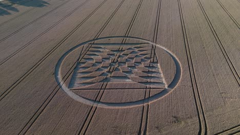 aerial flyover view above micheldever station geometric alien crop circle artwork tilt up to harvest farmland countryside