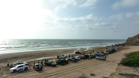 Gente-Reunida-En-La-Playa-De-Gadani-Para-Una-Carrera-A-La-Deriva-Junto-Al-Mar-árabe,-Vista-Aérea-Panorámica-Del-Paisaje-De-La-Playa-De-Gadani,-Baluchistán,-Pakistán