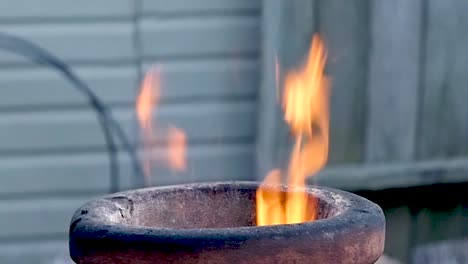 flames lick out the top of a terra-cotta chimenea during late evening