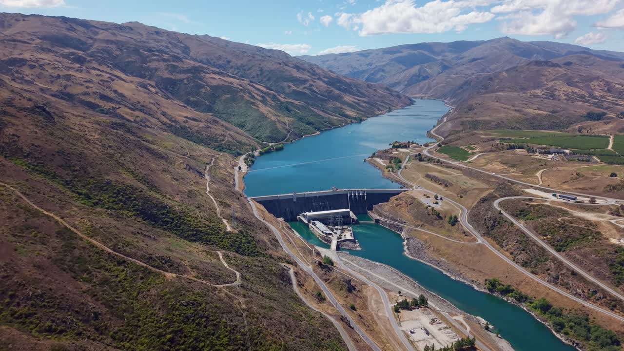 Aerial view of Clyde Dam and Lake Dunstan, New Zealand, under blue skies